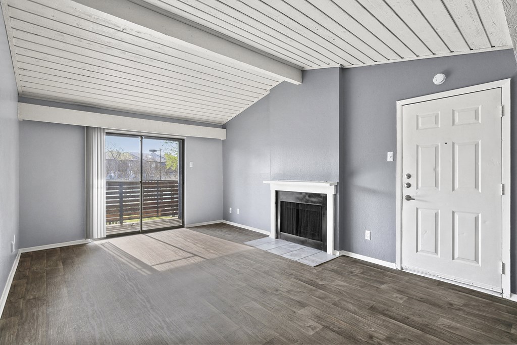 a living room with a fireplace and a door to a balcony