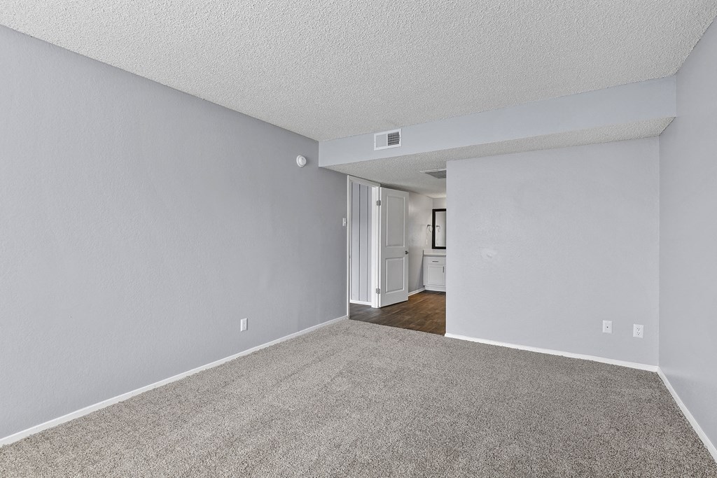an empty living room with white walls and carpet