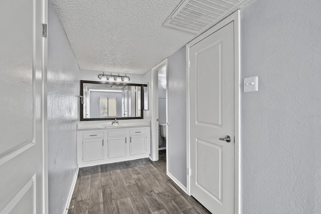 a white bathroom with a sink and a mirror