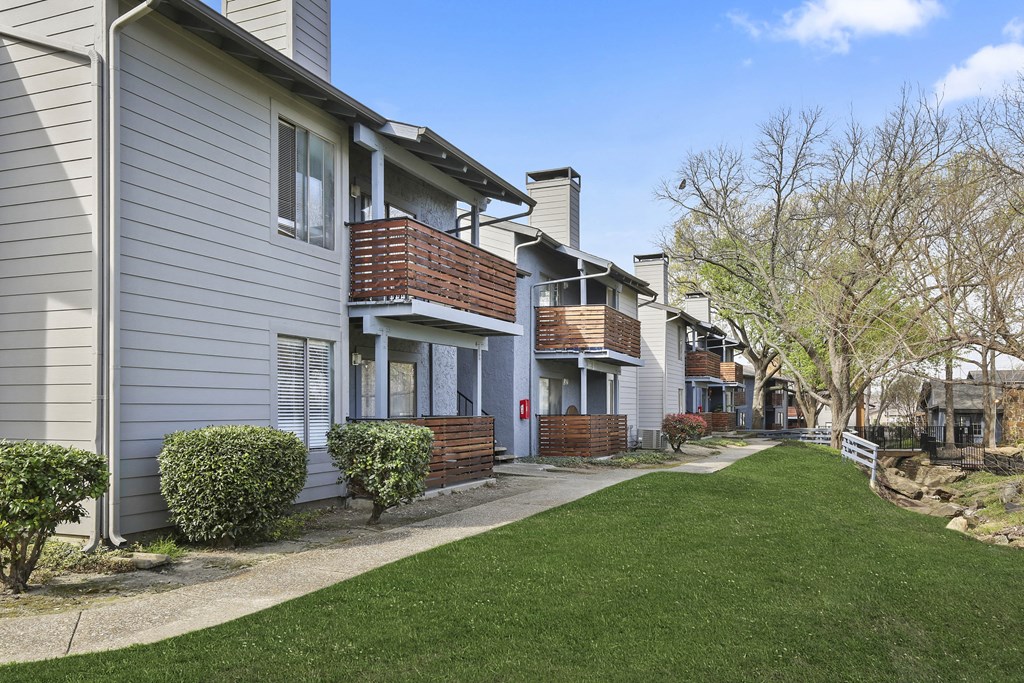 a row of houses with a sidewalk and lawn