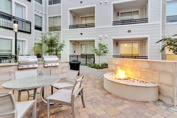 BBQ grills and outdoor seating area with nearby fire pit