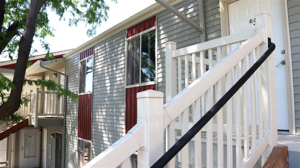 a small house with red and white doors and stairs