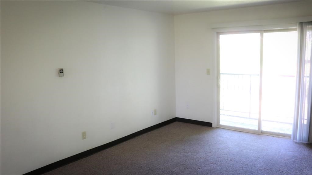 a living room with white walls and a window