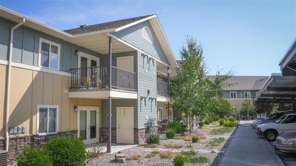 a row of houses with cars parked in front of them