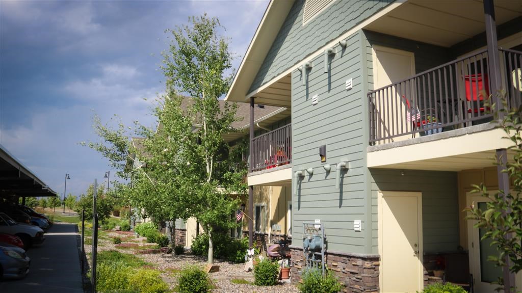 the side of a house with a balcony and trees