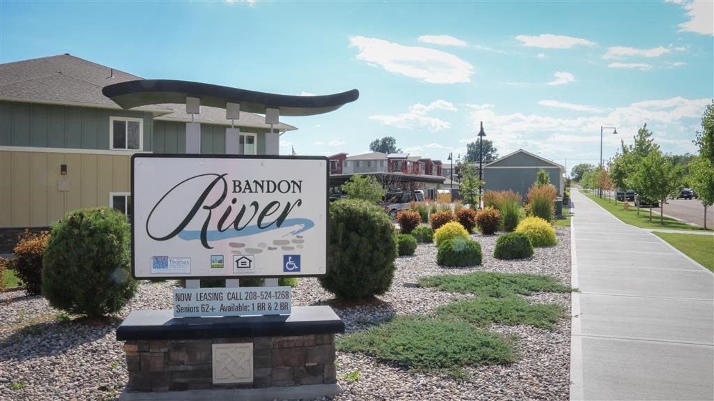 a sign sits in front of a street with houses