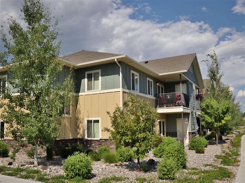 a house with trees and bushes in front of it