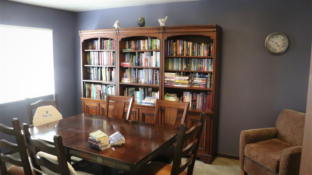 a dining room with a table and chairs and a bookcase