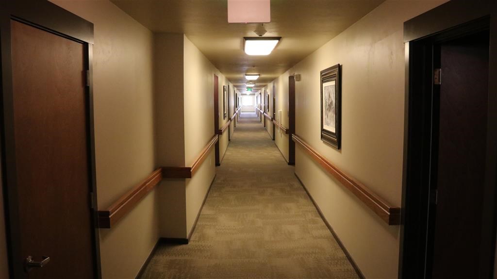 a long hallway with doors and a light in the end