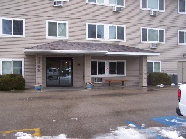 a house with a driveway and a bench in front of it