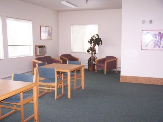 an empty living room with chairs and tables