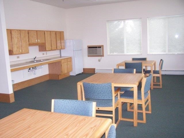 an empty room with a dining table and chairs