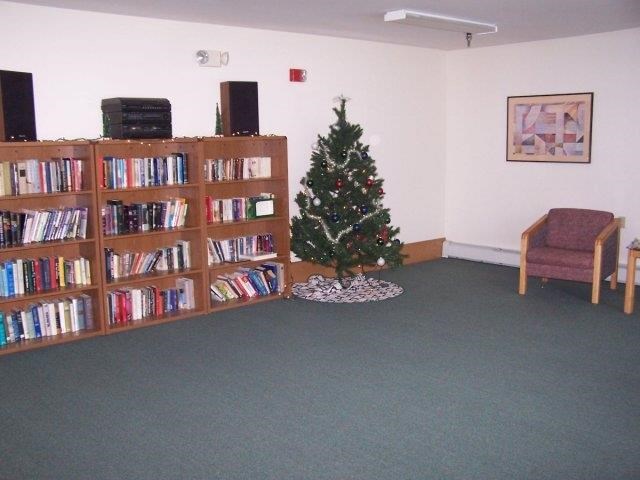 a christmas tree in the corner of a library