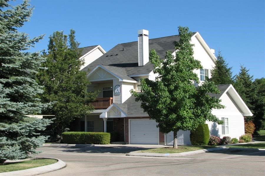 a white house with a garage and trees