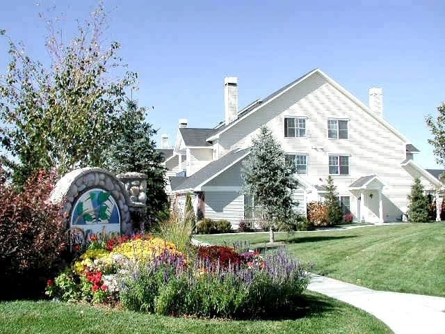 a house with a garden and a sign in front of it