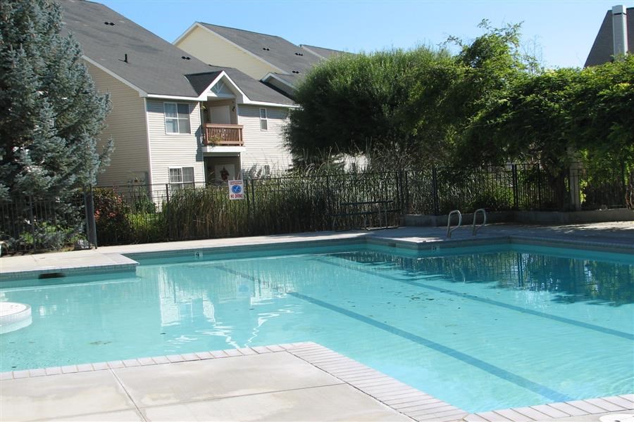 a swimming pool with a house in the background