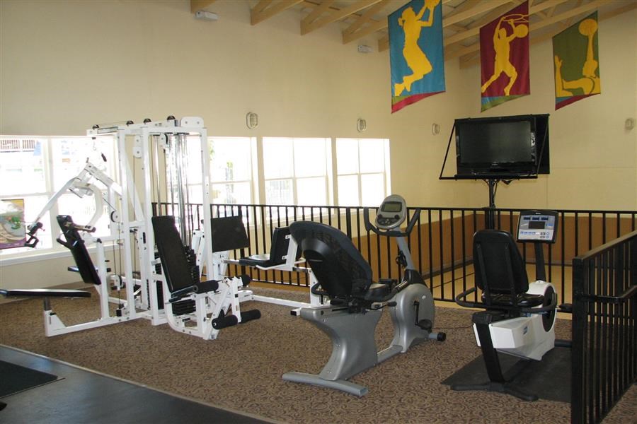 a gym with weights and a tv in a room