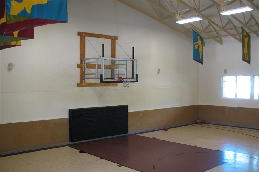a gym with a basketball hoop on the wall
