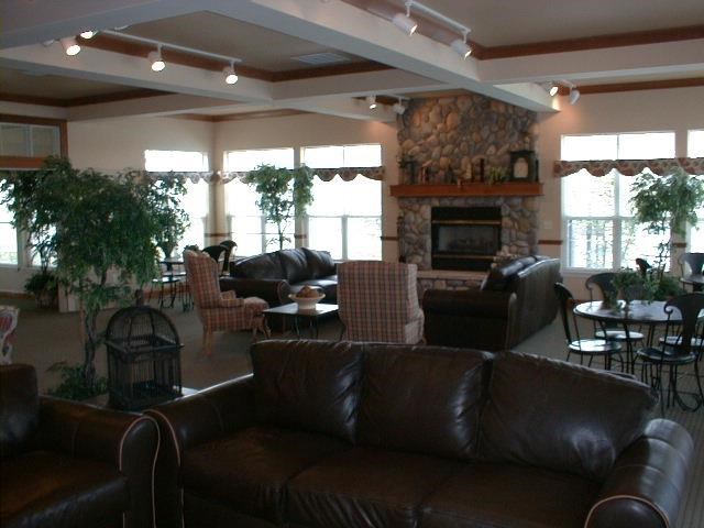 a living room with leather couches and chairs and a fireplace