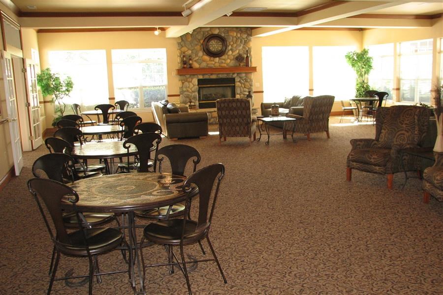 a living room with tables and chairs and a fireplace