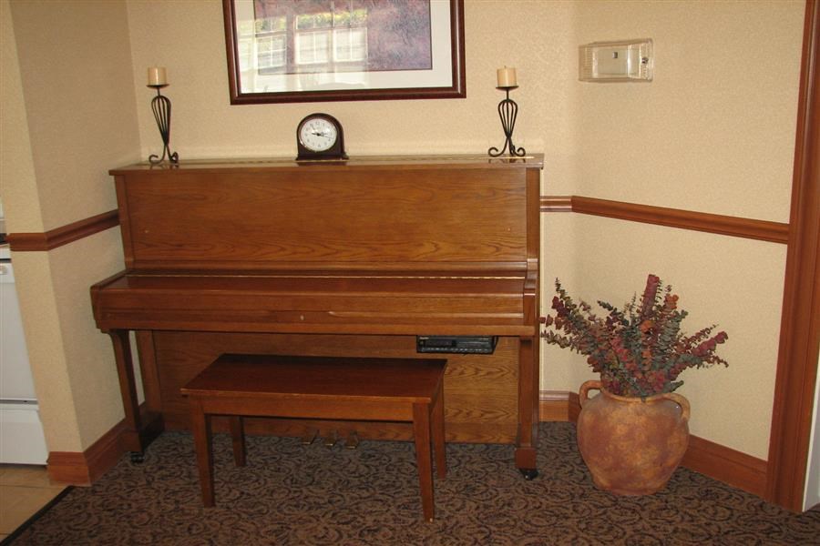 a piano in a room with a vase of flowers