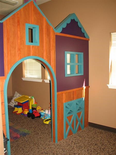 a play house with a blue door and a window