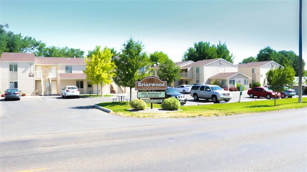a street with a sign in front of some apartments