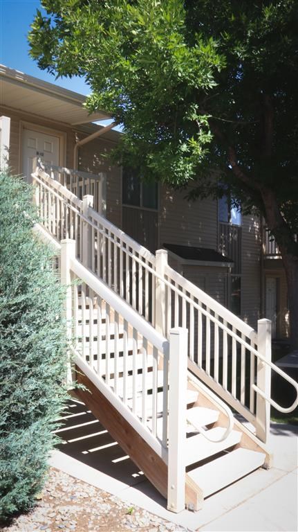 a white railing on a porch in front of a house