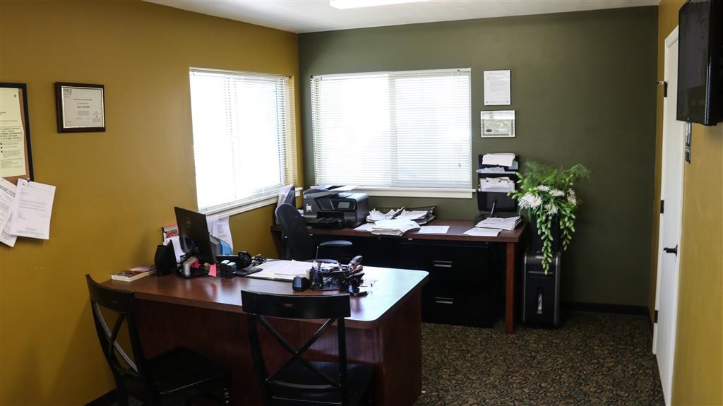 an office with two desks and two windows