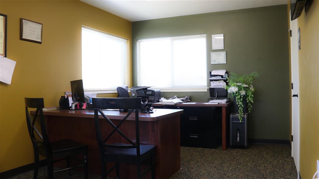 an office with a desk and two windows