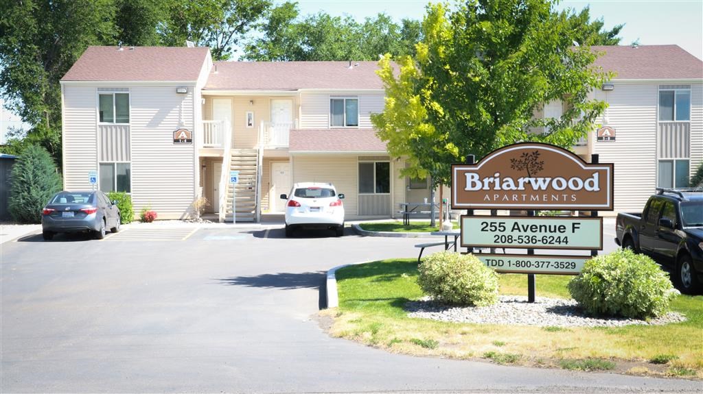 a sign apartments in front of a parking lot