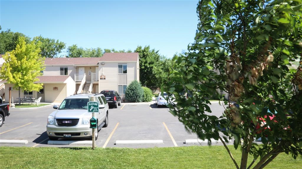 a parking lot with cars parked in front of apartments