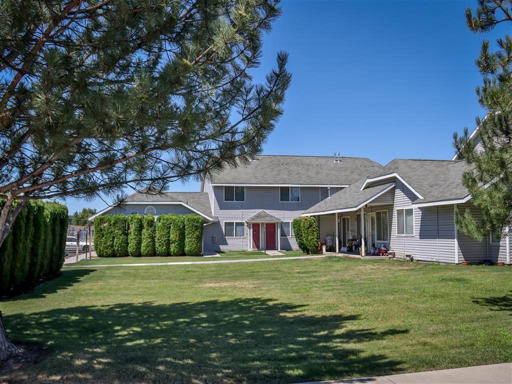 a house with a lawn and trees in front of it