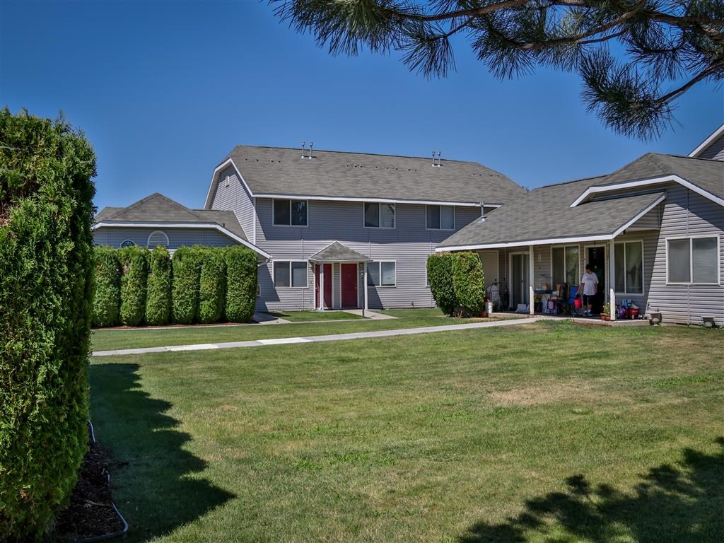 a house with a lawn and trees in front of it