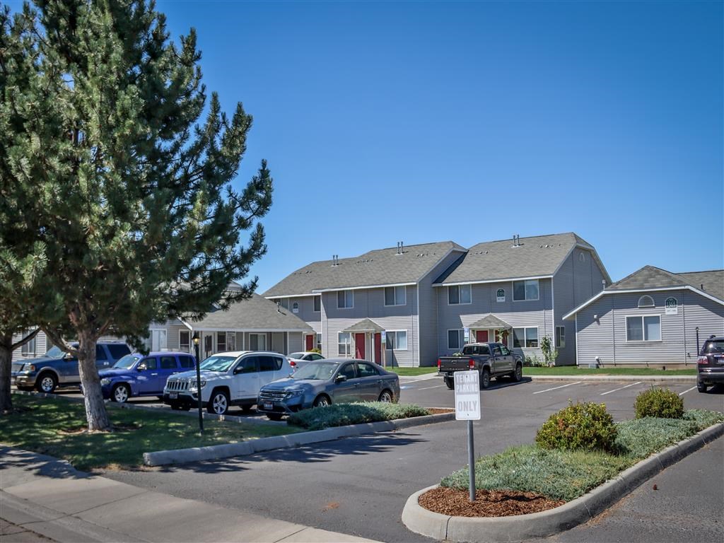 a parking lot with cars parked in front of houses