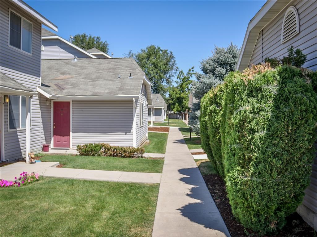 a sidewalk in front of a row of houses