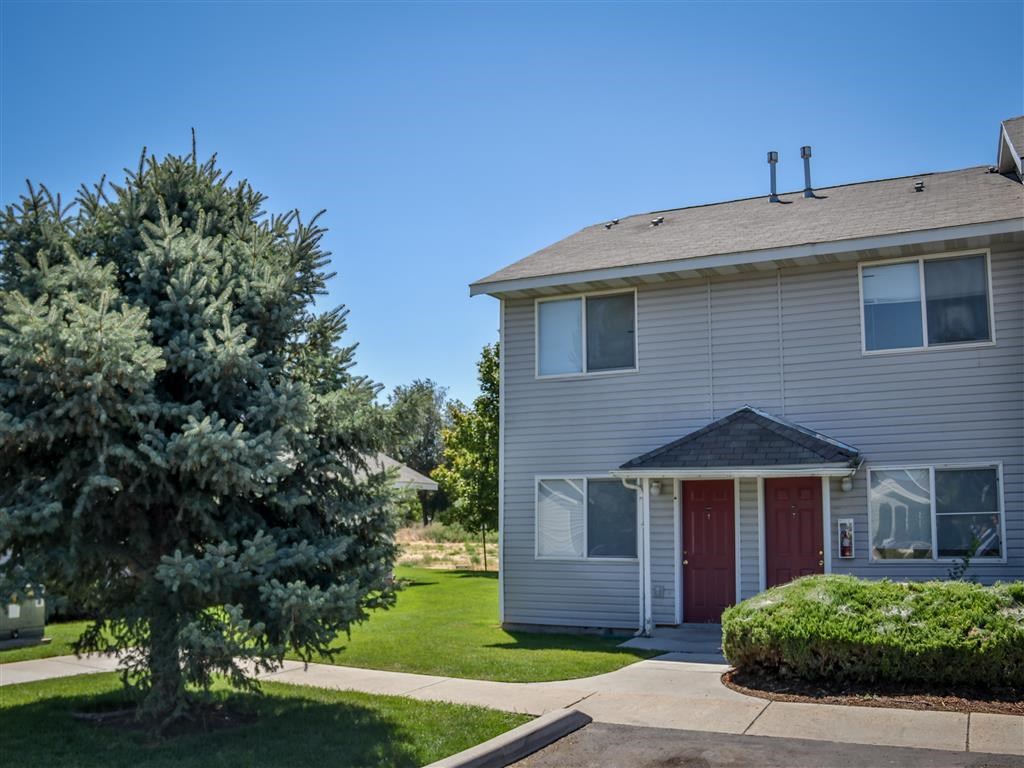 a white house with a red door and a tree