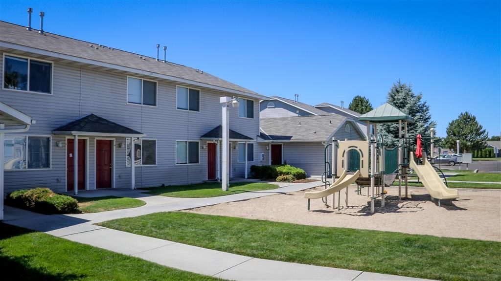 a yard with a swing set in front of a house