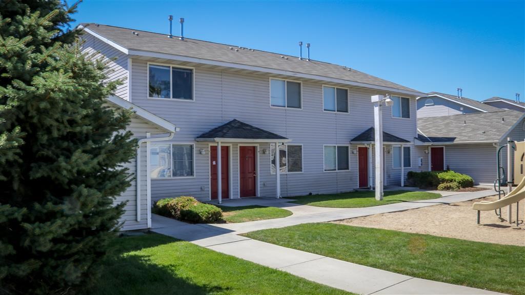 a white house with red doors and a sidewalk