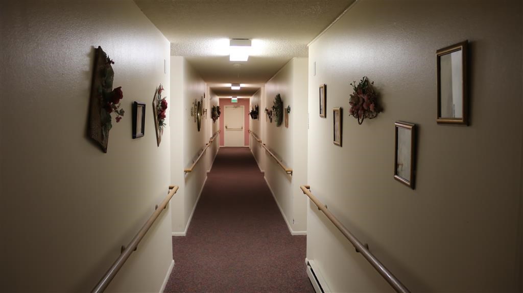 a hallway with white walls and a red carpet