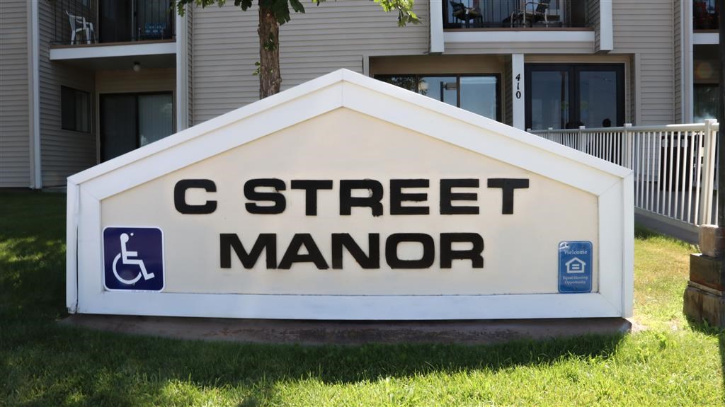 a sign for c street manor in front of a house