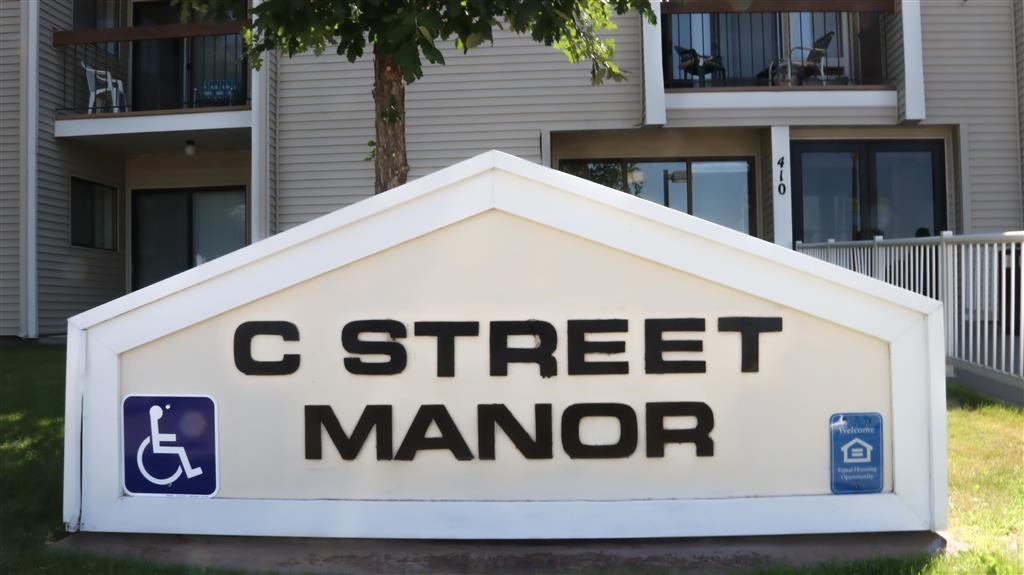 a sign for c street manor in front of a building