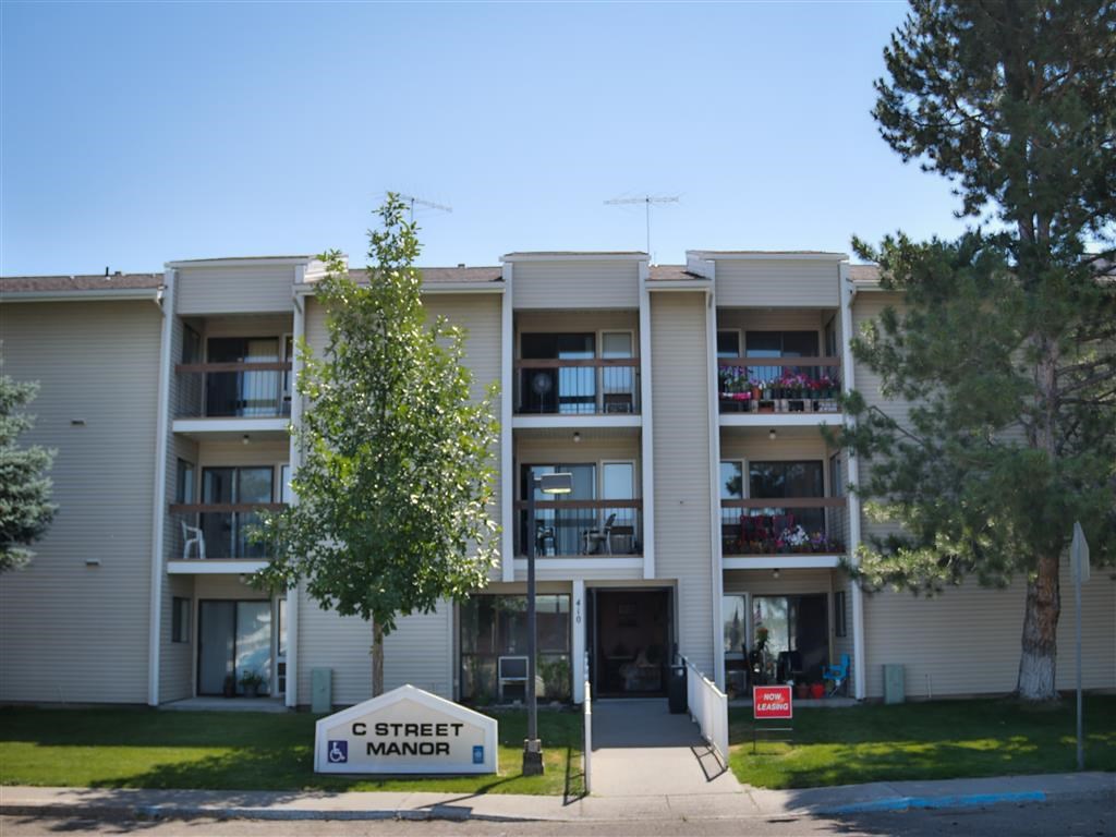 the exterior of an apartment building with a street sign in front