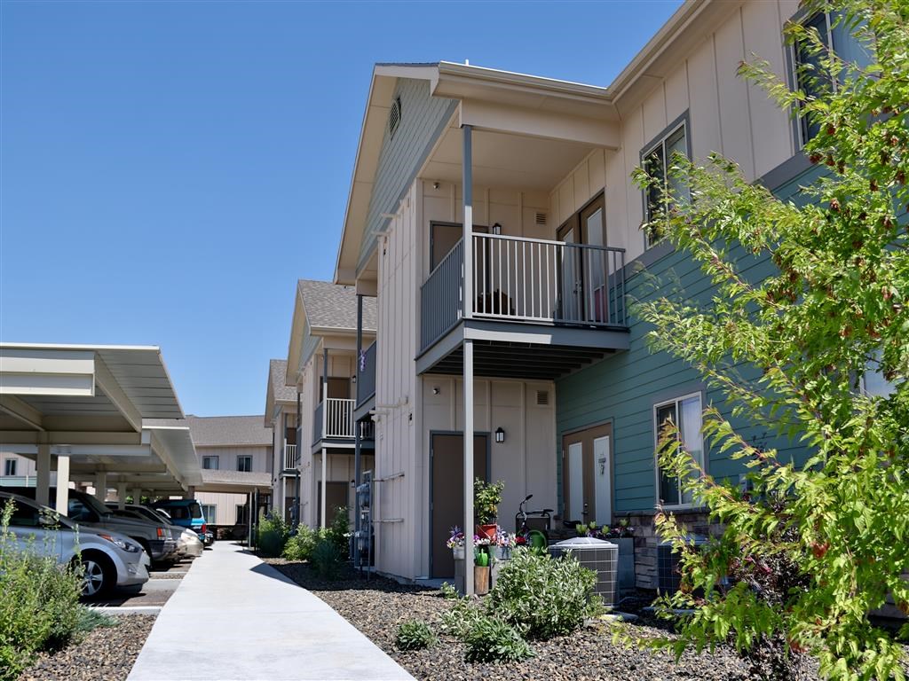 a row of apartments with balconies and a sidewalk