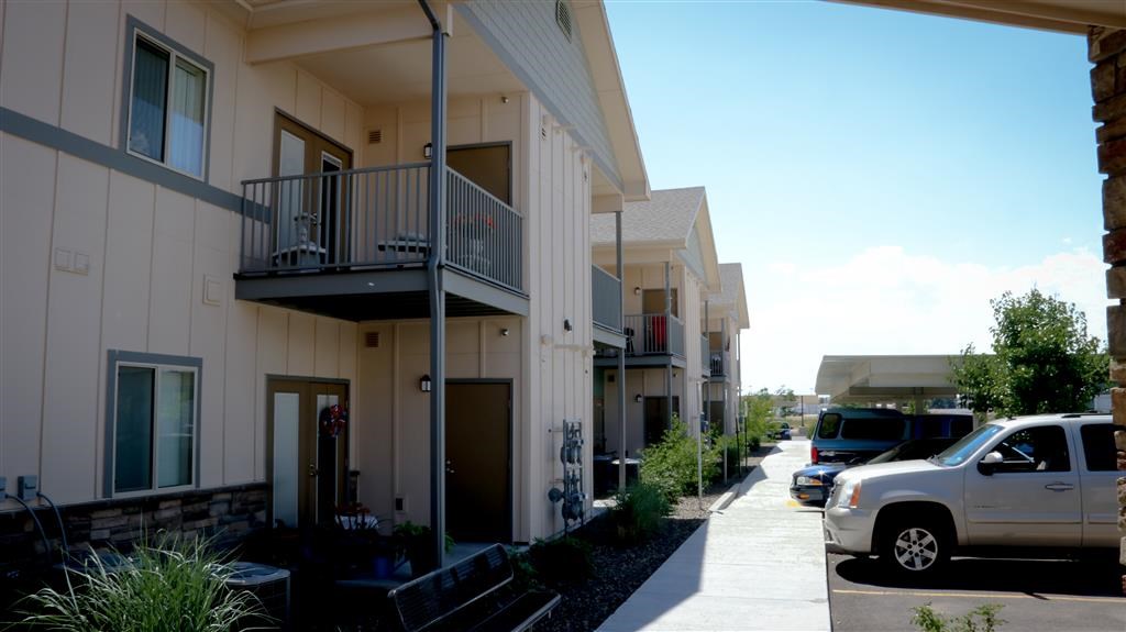 a row of houses with cars parked in front of them