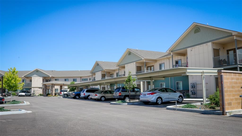 a parking lot with cars parked in front of buildings