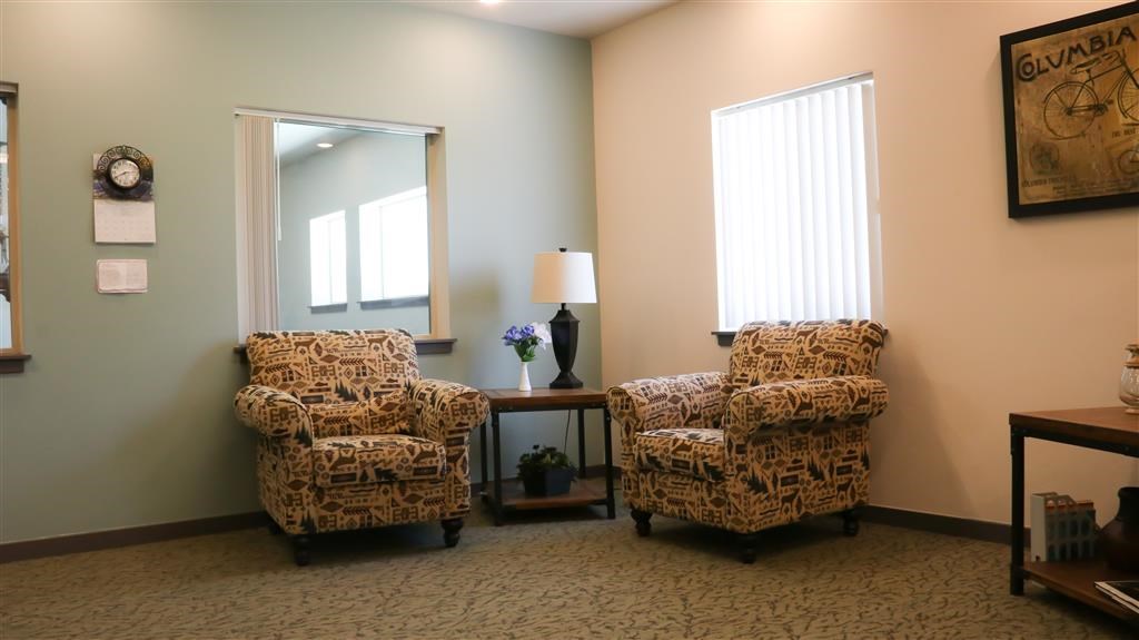 a living room with two chairs and a mirror