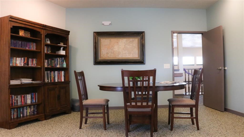 a dining room with a table and chairs and a bookcase