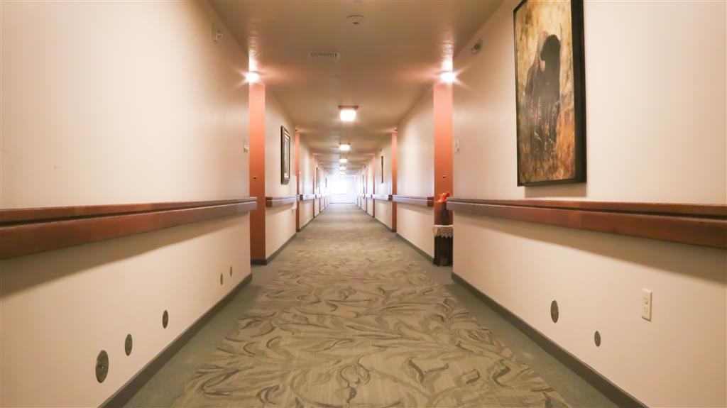 a hallway in a building with white and orange walls and a carpet