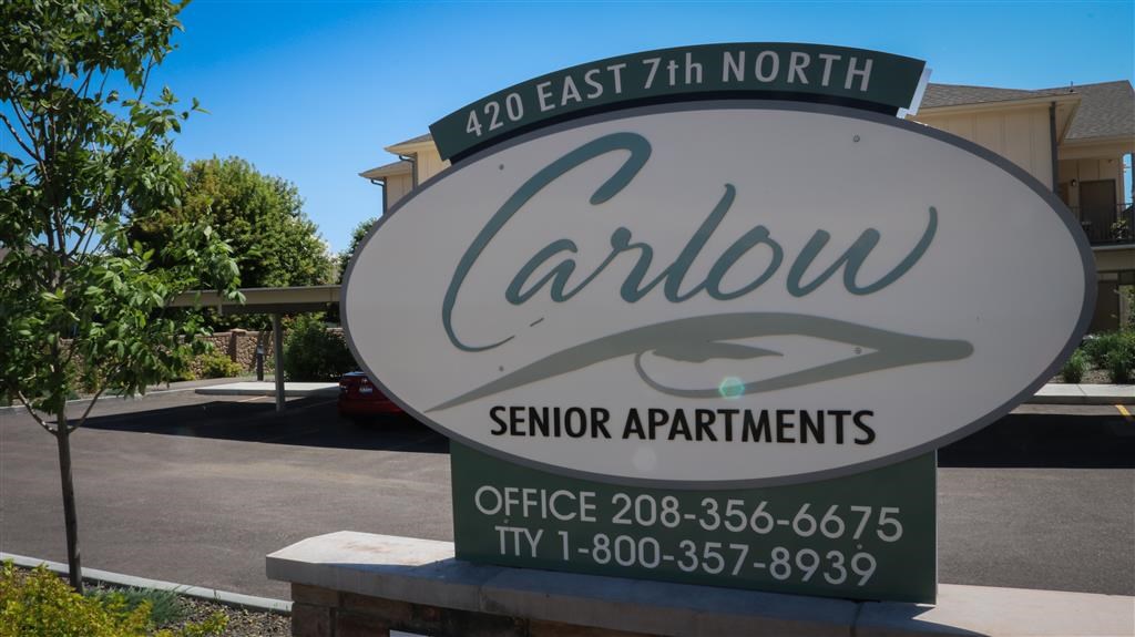 a sign for the carillon senior apartments in a parking lot